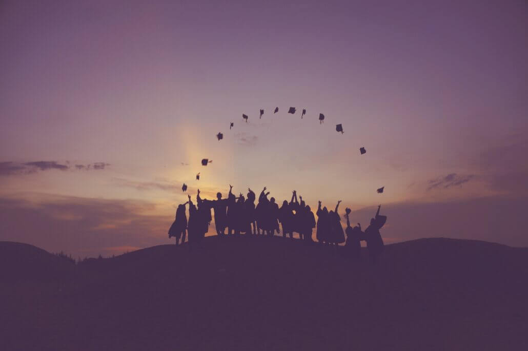 Silhouette of graduates on a hill
