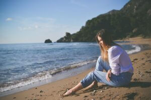 Single woman sitting on a beach