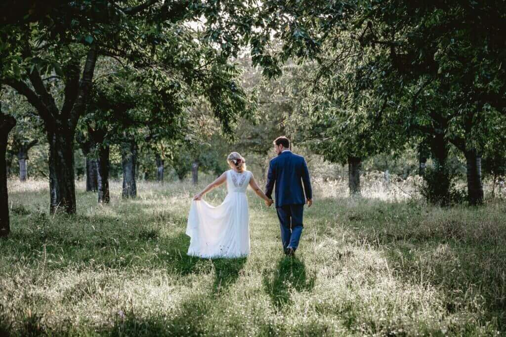 Wedding couple walking in sunny forest